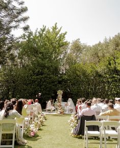 an outdoor wedding ceremony with white chairs