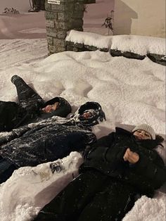 two people are laying in the snow