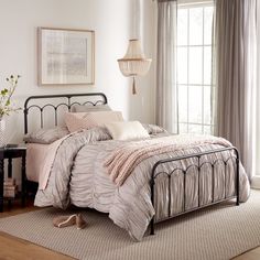 a bed room with a neatly made bed next to a window and a rug on the floor