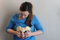 a woman is holding two different types of food in her hands and looking down at it