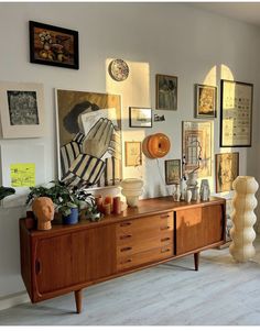 a living room filled with furniture and pictures on the wall