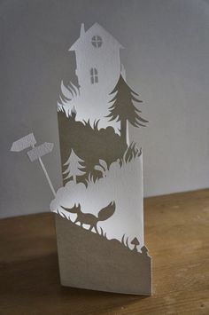 a paper cut out of a house and trees