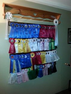 there are many bags hanging on the wall with ribbons attached to each bag, and one has a clock above it