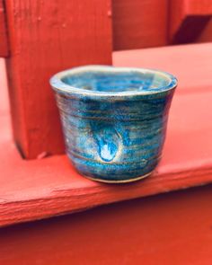 a blue cup sitting on top of a red bench