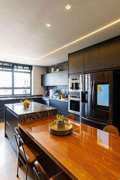 a modern kitchen with an island in the middle and stainless steel appliances on both sides