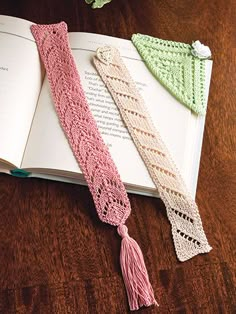 two crocheted ties are on top of an open book