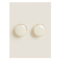 two white and gold earrings on a white background, one has a small round button in the middle