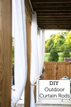 an outdoor curtain rod is attached to the side of a wooden structure with white drapes