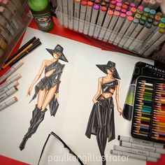 a drawing of a woman in a black dress and hat on paper next to crayons