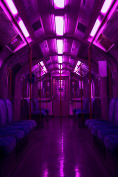 an empty train car with purple lights on the ceiling and seats in the front row