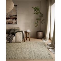 a living room with a couch, table and potted plant