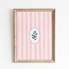 a pink and white striped wall with a blue flower on the center, framed in an old wood frame