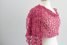 a pink crocheted shawl on a mannequin