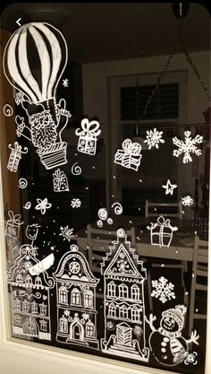 the window is decorated with black and white christmas stickers, including hot air balloons