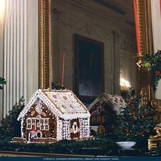 a house made out of gingerbread and decorated with icing is displayed in front of a mirror