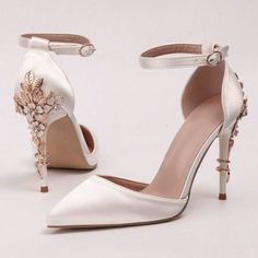 a pair of white high heels with flowers on them