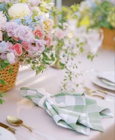 the table is set with flowers and place settings