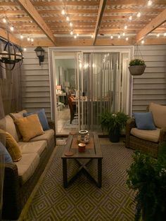 a living room with couches and lights on the ceiling