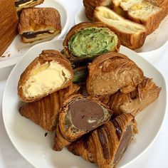 several pastries are arranged on two white plates, one is filled with cream cheese and the other has an avocado