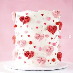 a white cake with red and pink hearts on it