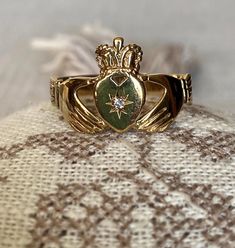 A traditional Claddagh ring with the lovely symbols of the HEART for love, the CROWN for loyalty and the clasped HANDS for friendship. This traditional Irish ring is part of the 'Fede Rings' ('Hands in Faith') dating from Ancient Rome and popular during the Middle Ages and Renaissance as engagement and wedding rings. This particular example sparkles with with the star set white stone in the center of the heart. - Size: US 11 1/4; UK W 1/2; France 65,5; Numero 25.5 (large size) - Weight: 2.73 gr Claddagh Wedding Bands, Clasped Hands, Irish Ring, Irish Ring Claddagh, Irish Rings, Engagement And Wedding Rings, Rome Antique, Claddagh Ring, Claddagh Rings