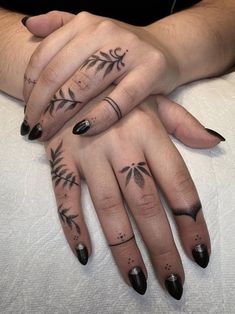 two hands with black and white tattoos on them