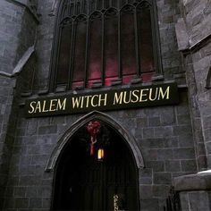 the entrance to salem witch museum is lit up with red lights and flowers on it