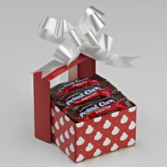 a red box filled with candy and wrapped in white ribbon