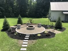 a fire pit in the middle of a yard with steps leading up to it and trees