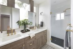 a bathroom with two sinks, mirrors and a shower stall in it's corner