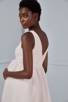 a woman in a white dress posing for the camera with her hand on her hip