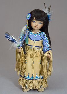 a doll dressed in native clothing with feathers