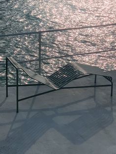 a metal lounge chair sitting on the beach