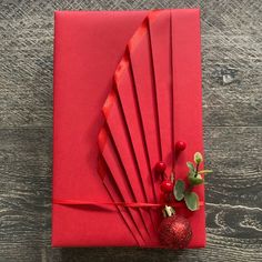 a red envelope with some ribbons and a flower on the inside, sitting on a wooden table