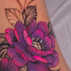 a woman's leg with a flower tattoo on it