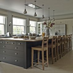 a large kitchen with an island and lots of stools in the middle of it