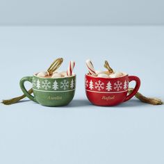 two christmas mugs with candy canes in them