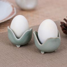 two eggs sitting in an egg holder on a table