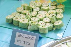 several different types of food on display in a store window with a sign that says seaweed wraps