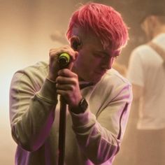 a man with pink hair holding a microphone