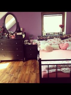 a bedroom with purple walls and wooden floors