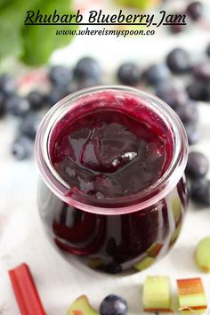 a jar filled with blueberry jam next to sliced apples