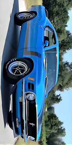 an aerial view of a blue car with its hood up and tires on it's side