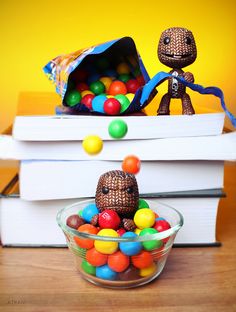 a bowl filled with lots of candy next to a stack of books