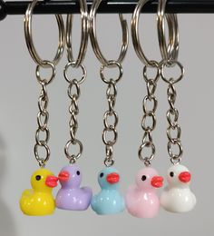 four rubber ducks hanging from a metal hook