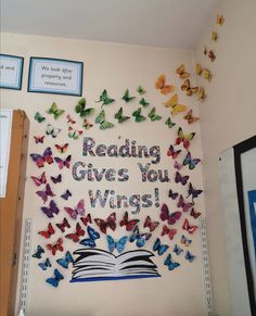 a wall with butterflies on it that reads reading gives you wings and there is a book in the middle