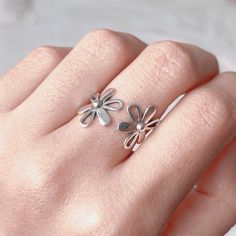 This dainty nature inspired floral ring is entirely made of 925 sterling silver, featured with two daisy flowers. Lovely on its self or stacked with other rings, it is designed to connect your personal expression with self-identity that goes far beyond. Fantastic to give as a gift or to simply treat yourself... ⭐️ ⇩⇩ PRODUCT INFO ⇩⇩ ⭐️ ► Metal: 925 sterling silver with hallmark (nickle free) ► Initial Band Diameter: approx 17.5 mm (UK Size O) ► Open band: adjustable to fit your size ► Hypoallergenic, comfortable to wear ♻️ Eco-Packaging: beautifully wrapped up inside a Kraft box, ready for gift giving! 🌟 GIFTING DIRECT!  FREE GIFT WRAPPING  Just simply mark your order as gift and leave your gift message. No invoices or receipts are included, I will hand write your message within a handmad Delicate Flower Ring For Spring, Delicate Spring Flower Ring, Adjustable Flower Ring For Spring Anniversary, Delicate Flower Shaped Ring For Spring, Flower-shaped Promise Ring For Spring, Spring Flower Shaped Promise Ring, Spring Flower-shaped Promise Ring, Spring Flower Promise Ring, Spring Anniversary Adjustable Flower Ring