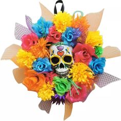 a skull with colorful flowers on it's head is hanging from a hook in the shape of a wreath