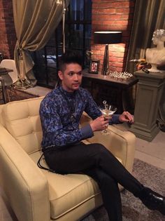 a man sitting in a chair holding a martini