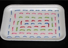 a white plate with colorful designs on it sitting on a black tableclothed surface